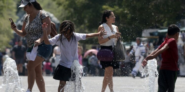 Children cool themself down in a water fountain during a heat wave hitting the country in Guadalajara, Jalisco state, Mexico, on May 23, 2024. (Photo by ULISES RUIZ / AFP)