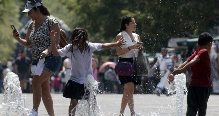 Children cool themself down in a water fountain during a heat wave hitting the country in Guadalajara, Jalisco state, Mexico, on May 23, 2024. (Photo by ULISES RUIZ / AFP)