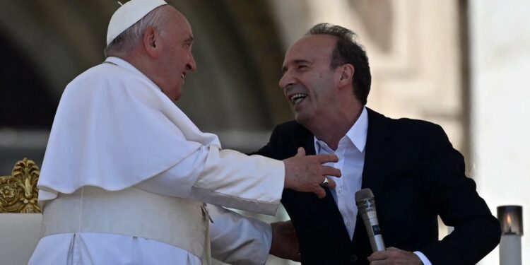 Pope Francis (L) embraces Italian film director Roberto Benigni following his speech during a mass on World Children's Day at St Peter's Basilica in the Vatican on May 26, 2024. (Photo by Filippo MONTEFORTE / AFP)