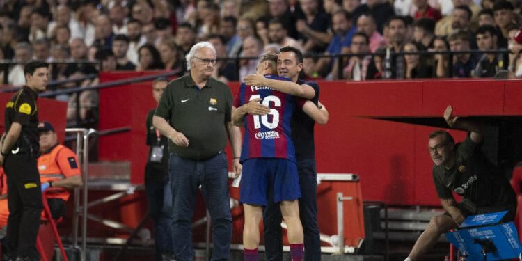Barcelona's Spanish midfielder #16 Fermin Lopez celebrates scoring a goal with Barcelona's Spanish coach Xavi Hernandez during the Spanish league football match between Sevilla FC and FC Barcelona at the Ramon Sanchez Pizjuan stadium in Seville on May 26, 2024. (Photo by JORGE GUERRERO / AFP)