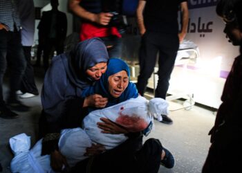 Una mujer palestina sostiene el cuerpo amortajado de un niño muerto en un bombardeo israelí, en una clínica de salud en el área de Tel al-Sultan en Rafah. Foto AFP.