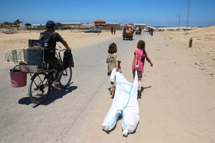 Palestinian children use a hazmat suit to transport belongings as they flee the area of Tel al-Sultan in Rafah in the southern Gaza Strip on May 30, 2024, amid the ongoing conflict between Israel and the militant group Hamas. (Photo by Eyad BABA / AFP)