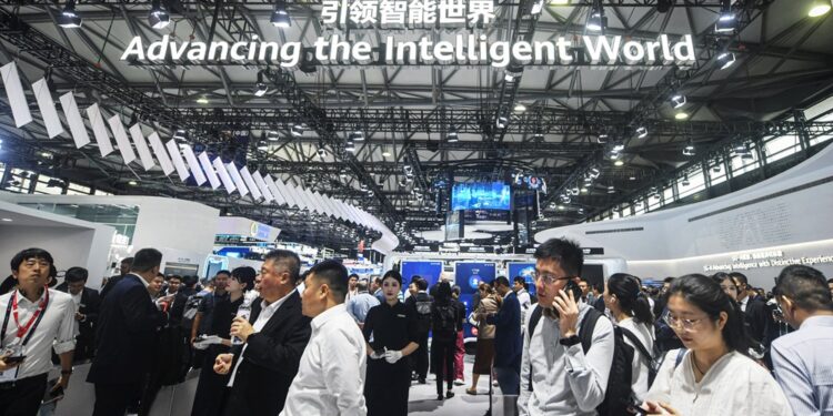 People walk past a Huawei booth at the Mobile World Congress (MWC) in Shanghai on June 26, 2024. (Photo by AFP) / China OUT